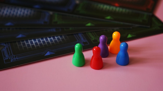 写真 ピンクの背景に色付きのボードゲームフィギュア
