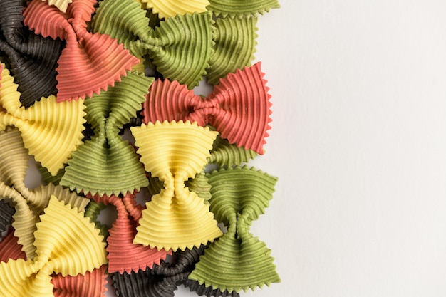 Colored bow tie pasta. Closeup multiple farfalle isolated on white background.