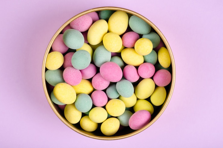 Photo colored candies composition on purple background, party and celebration decoration.