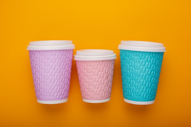 Colored cardboard coffee cups on a bright background