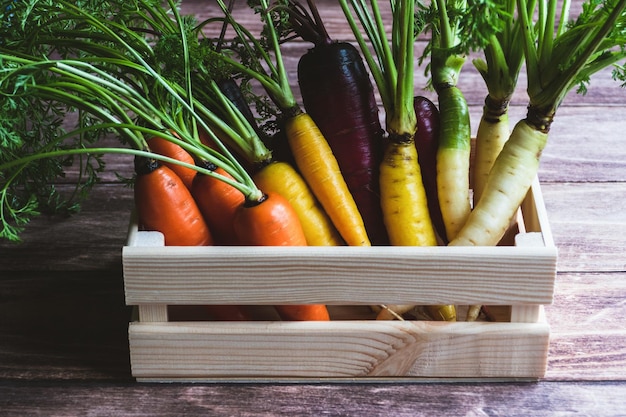 Colored carrots in wooden box on kitchen table