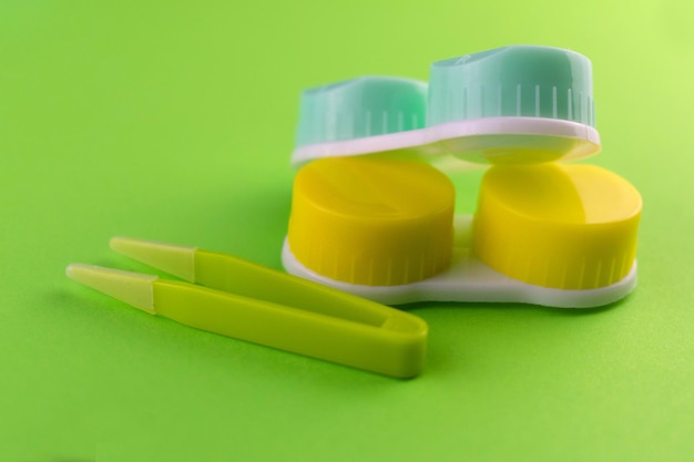 Colored cases for contact lenses for eyes on a green background