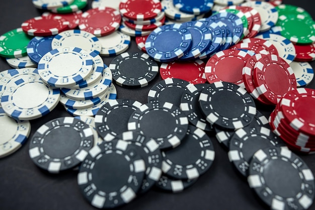 Colored casino poker chips scattered on a black table