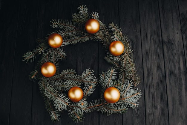 Colored christmas decorations on black wooden table Xmas balls on wooden background Top view copy space new year