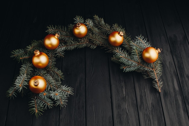 Colored christmas decorations on black wooden table. Xmas balls on wooden background.