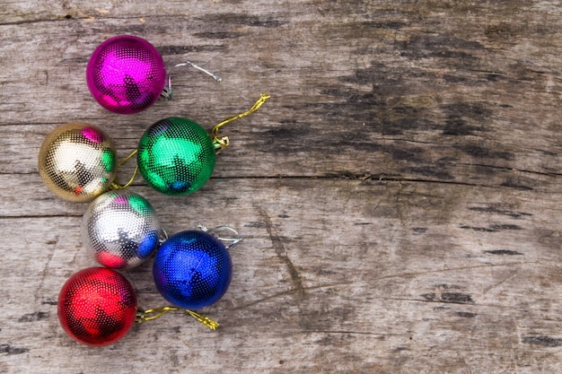 Colored christmas decorations on rustic wooden table. Xmas balls on wood background. Top view, copy space