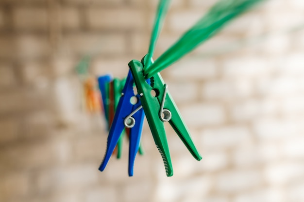 Colored clothespins hanging on a green rope