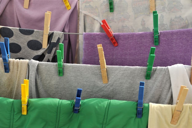 Colored clothespins hold the clothes on a rope