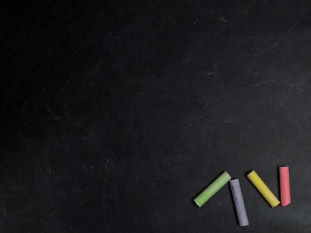 Colored crayons on a blackboard background.