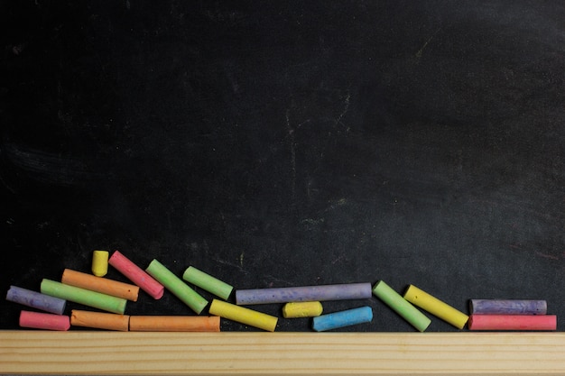 Colored crayons on a blackboard background.