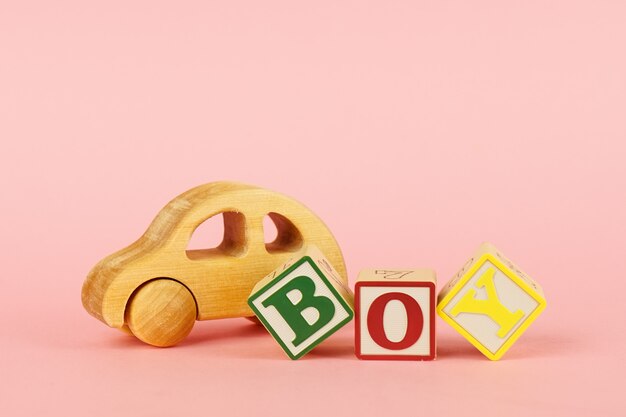 Colored cubes with letters Boy and toy on a pink 