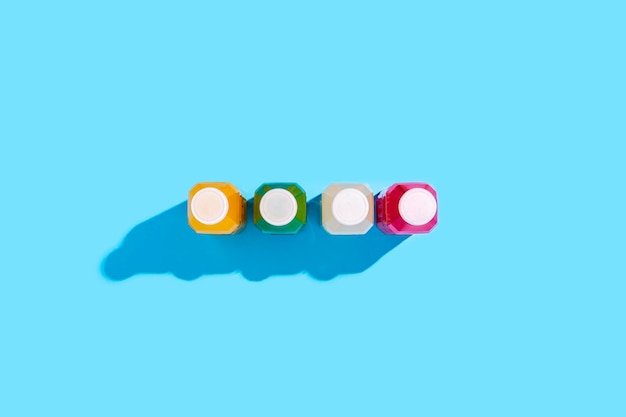 Colored detox drink in plastic bottles on a blue background. Top view, flat lay.