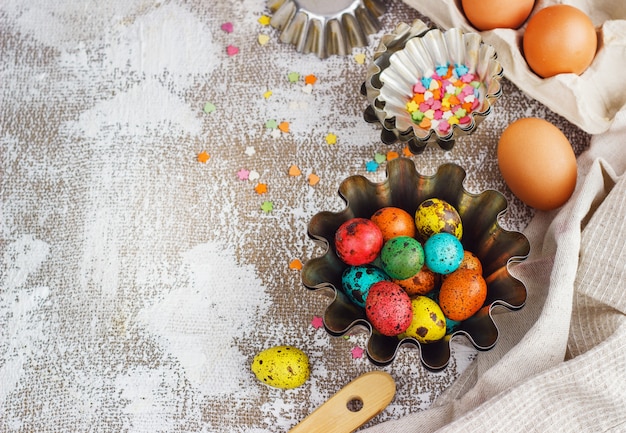 가벼운 캔버스 배경에 착 색된 부활절 달걀과 베이킹 금형