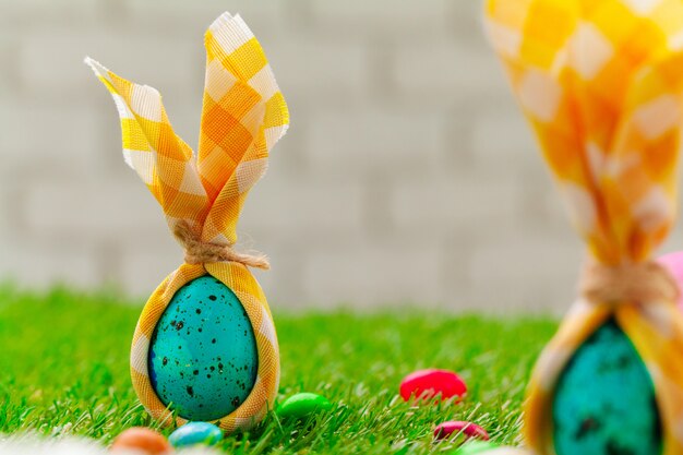 Colored Easter eggs on grass decorated with flowers