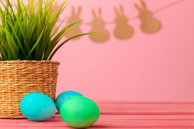 Colored eggs for Easter with pot of artificial grass