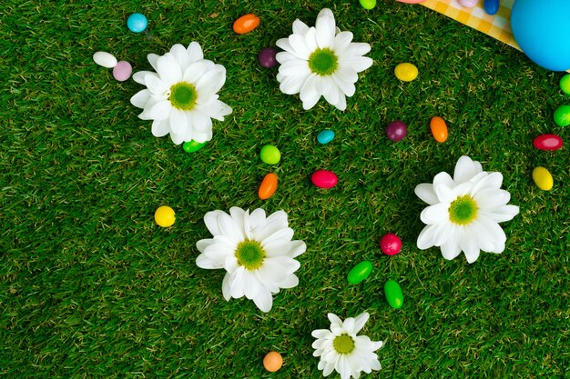 Colored eggs and vibrant candies on grass. Easter composition