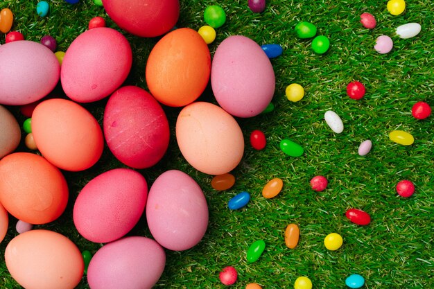 Colored eggs and vibrant candies on grass