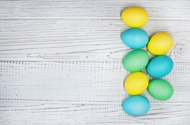 Colored eggs on a white wooden background. Concept Happy Easter.