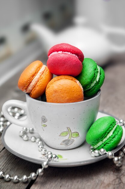 Colored macarons on wooden table.