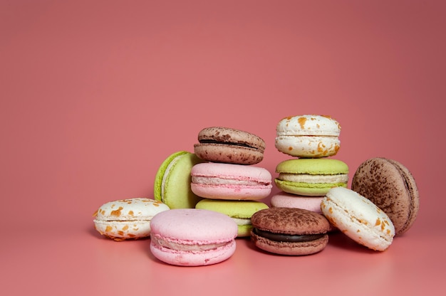 colored macaroons lined up on pink background