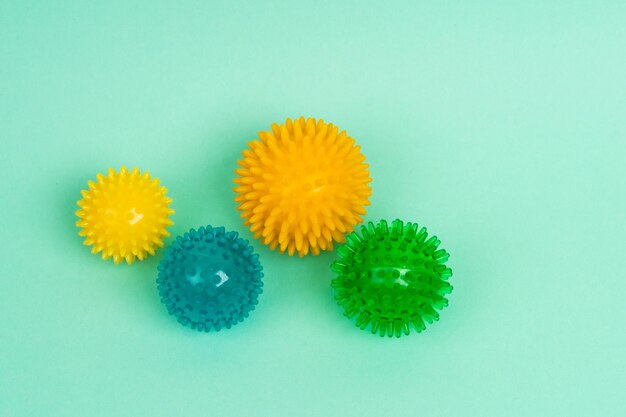 Цветные массажные игольчатые шарики разных размеров на бирюзовом фоне концепция профилактики