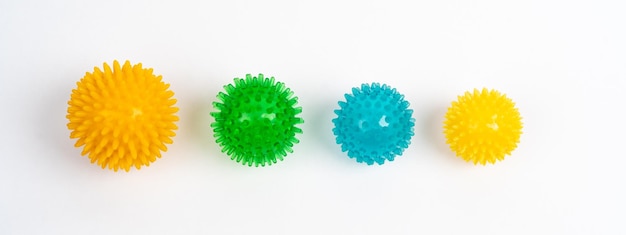 Цветные массажные игольчатые шарики разных размеров на белом фоне концепция профилактики