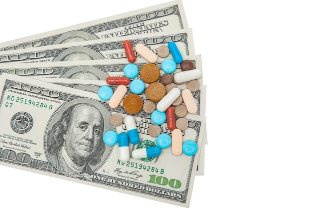 Pillole medicinali colorate e dollari americani su sfondo bianco