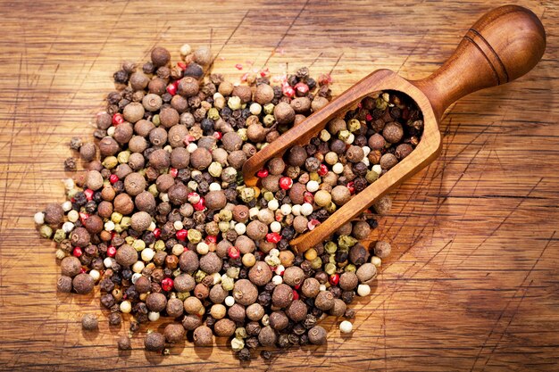 Colored mixed pepper on a wooden table