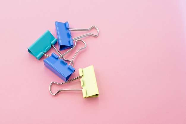 Colored paper clips on a pink background. Office stationary 
