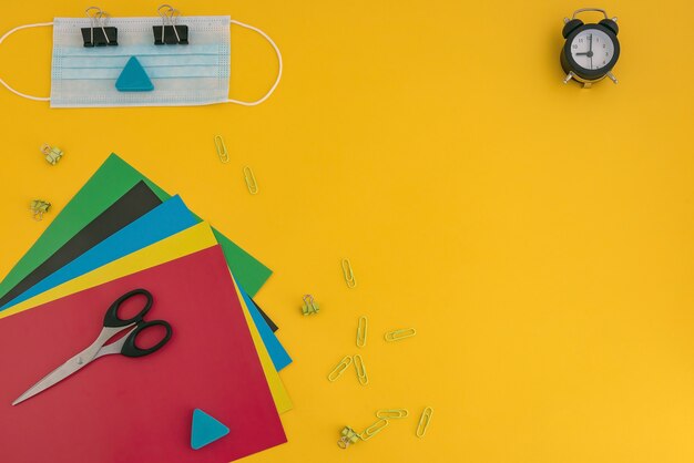 Colored paper scissors watches face mask and paper clips