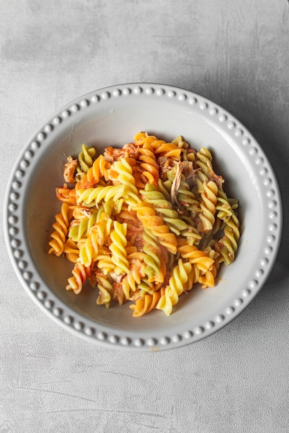 colored pasta in plate on rustic background