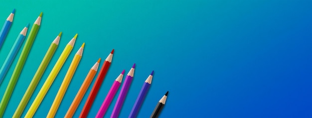 Colored pencil group isolated on blue Panoramic banner background