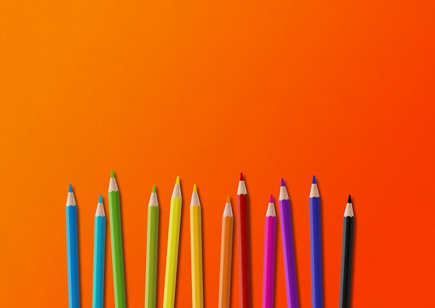 Colored pencil group isolated on orange Horizontal background