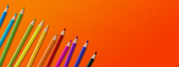 Colored pencil group isolated on orange Panoramic banner background