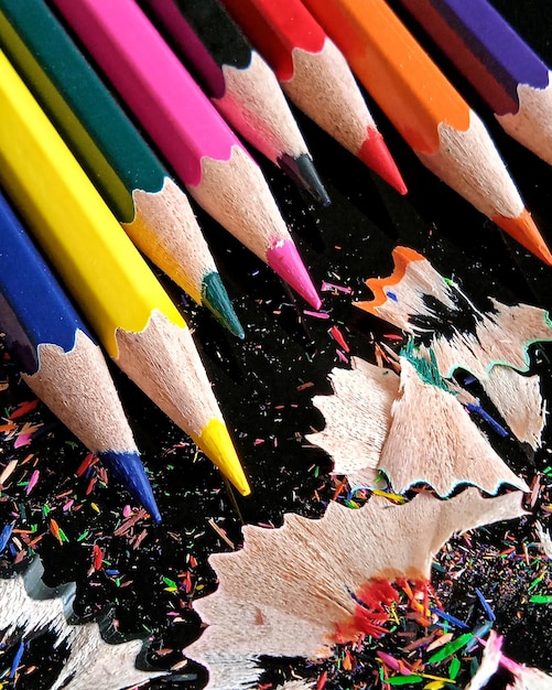 Фото Цветные карандаши и осколки карандаша на черном фоне