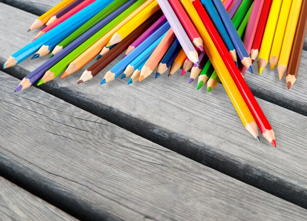 Цветные карандаши, расположенные в ряд на фоне