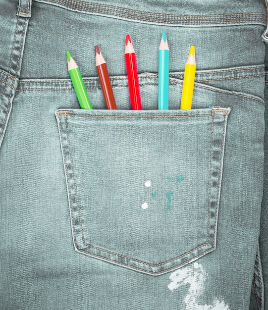 Colored pencils in the back pocket of blue jeans