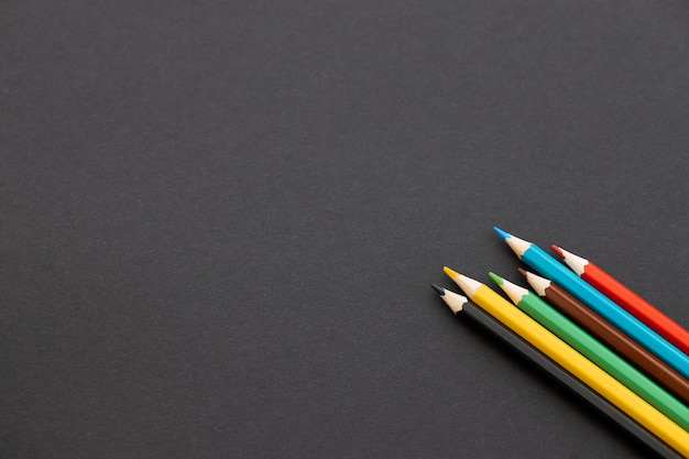 Photo colored pencils on black background back to school concept