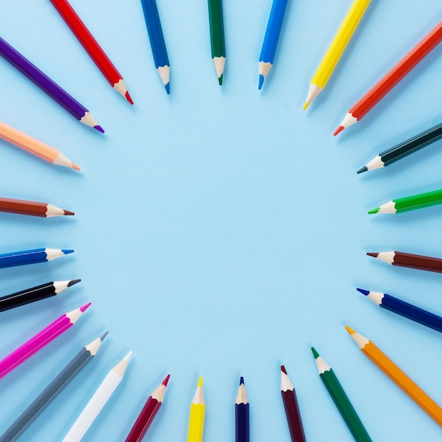 Colored pencils in the form of a circle on a blue background Back to school concept