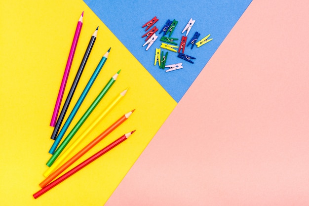 Colored pencils lie like a fan on a tricolor background