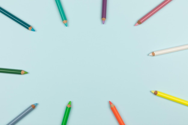 Colored pencils on a light blue background top view