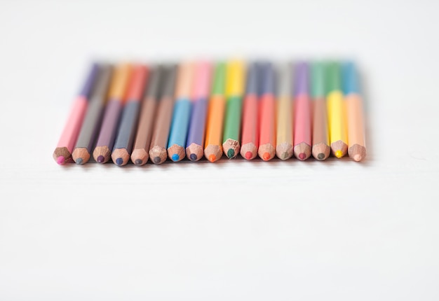 白い背景に、教育フレームコンセプトに分離されたコピースペースと色鉛筆。