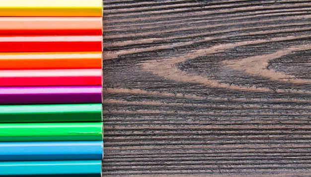 Colored pencils on a wooden background