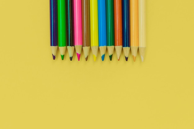 Colored pencils on a yellow background