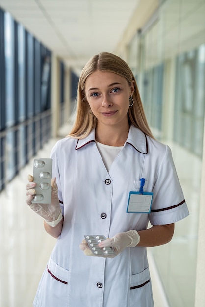 Colored pills on the hands of young nurse in gloves