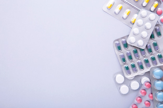 Photo colored pills and tablets in blister on a grey , top view