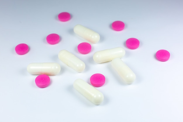 Colored pills on white background. Close up. Medical treatment concept.