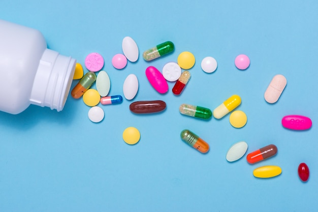 Colored pills with bottle  on blue background.