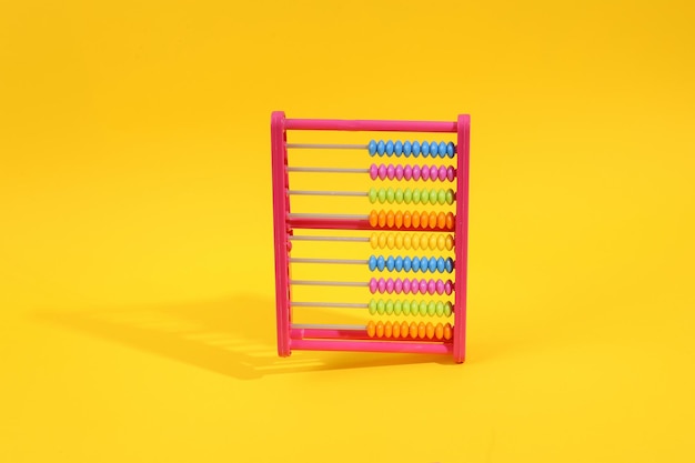 Colored plastic abacus on yellow background