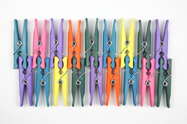 Colored plastic clothespins for clothes on a white background